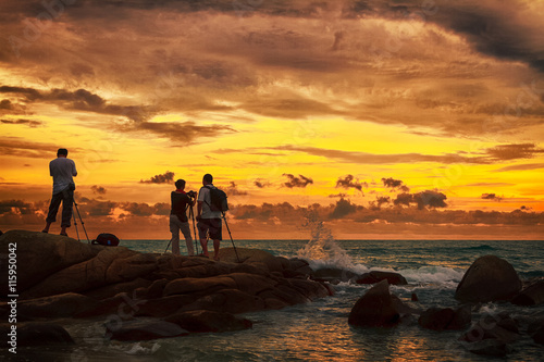 Photographer taking photo on the beach during sunset © praisaeng