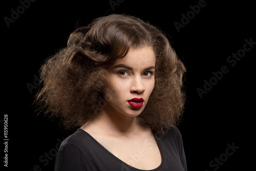 Portrait of beautiful lady with red lips over black background. Pretty model woman with modern hairstyle in studio.