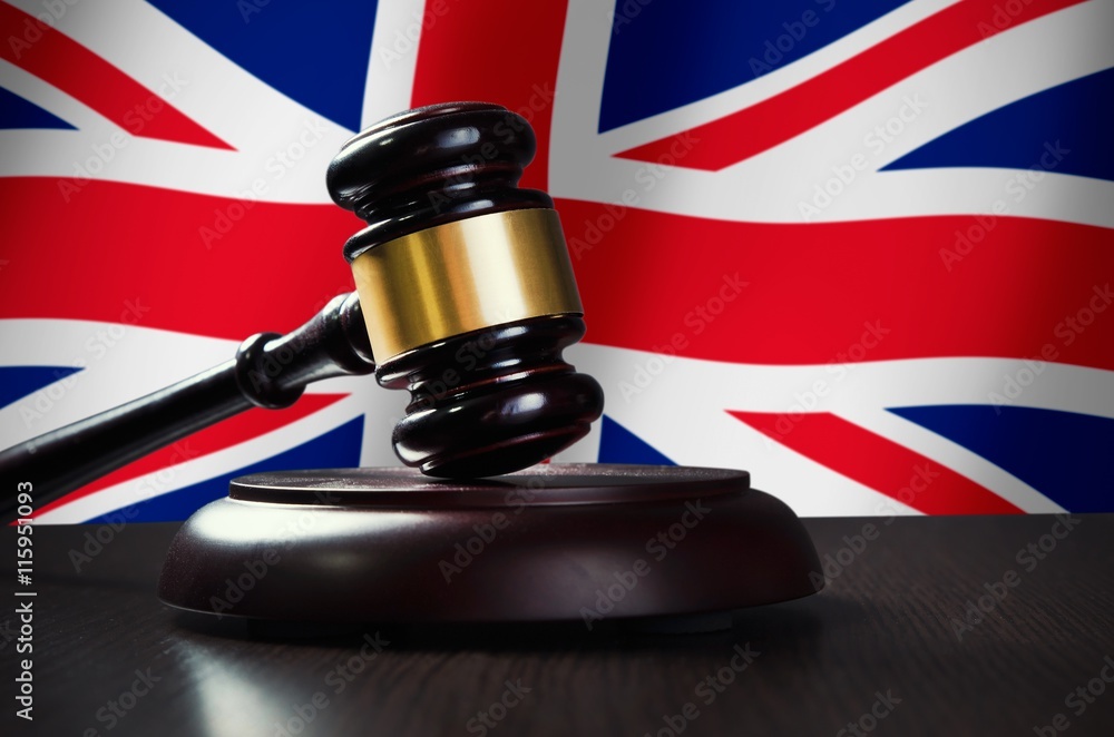 Wooden gavel with United Kingdom flag in background