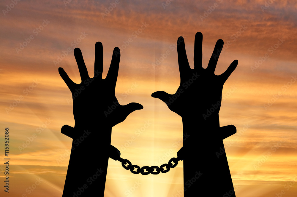 Silhouette of human hands in handcuffs