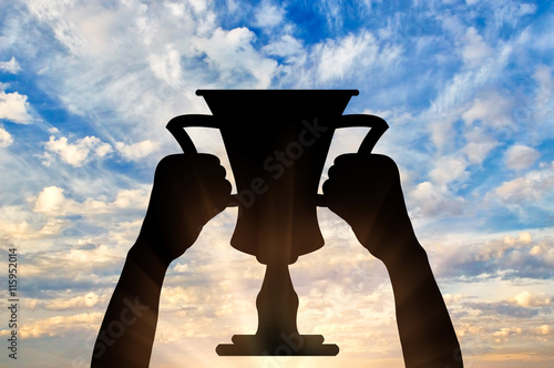 Silhouette of a hand holding a championship trophy