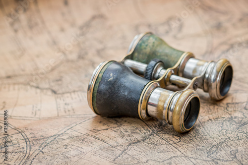 Pair of vintage binoculars on an ancient map