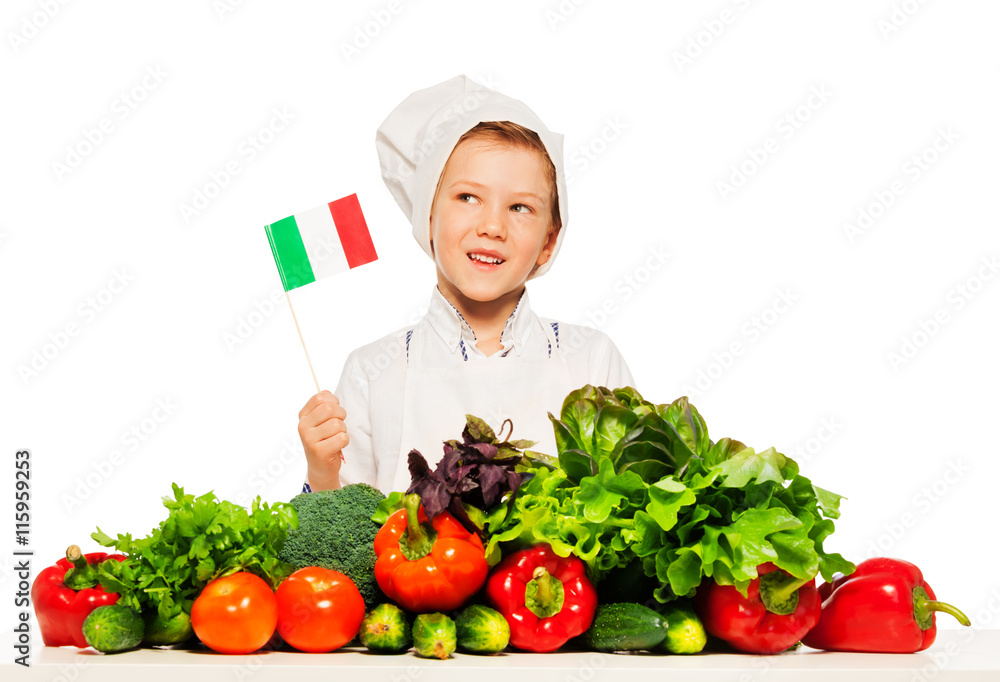 Italian boy in cook's toque preparing fresh salad Italian boy in cook's toque preparing fresh salad