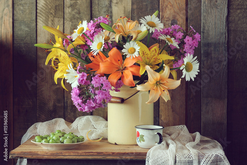 Fototapeta Naklejka Na Ścianę i Meble -  Still life with a bouquet of garden flowers and gooseberries.