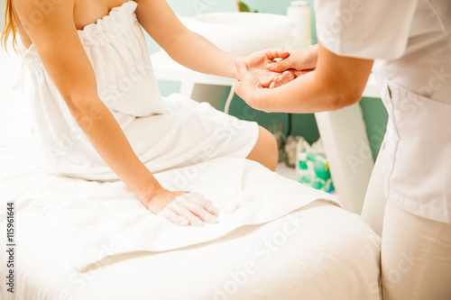 Therapist removing wax from client's hands