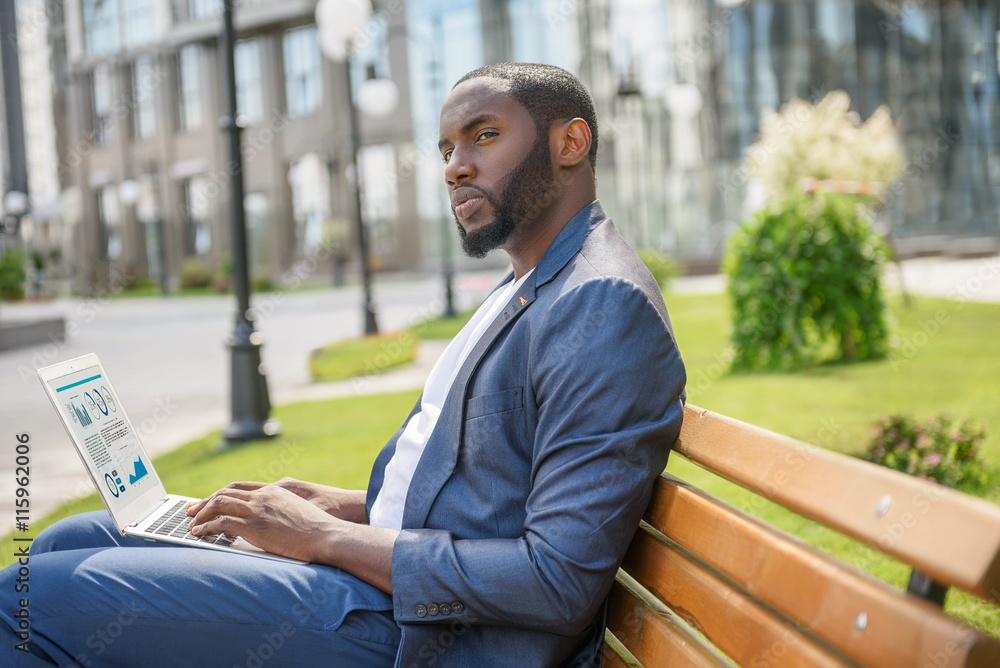 Confident young male worker with computer in town Confident young male worker with computer in town