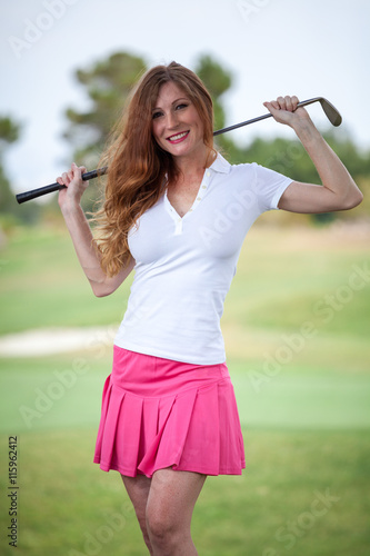 Beautiful woman golf caddy on course with club