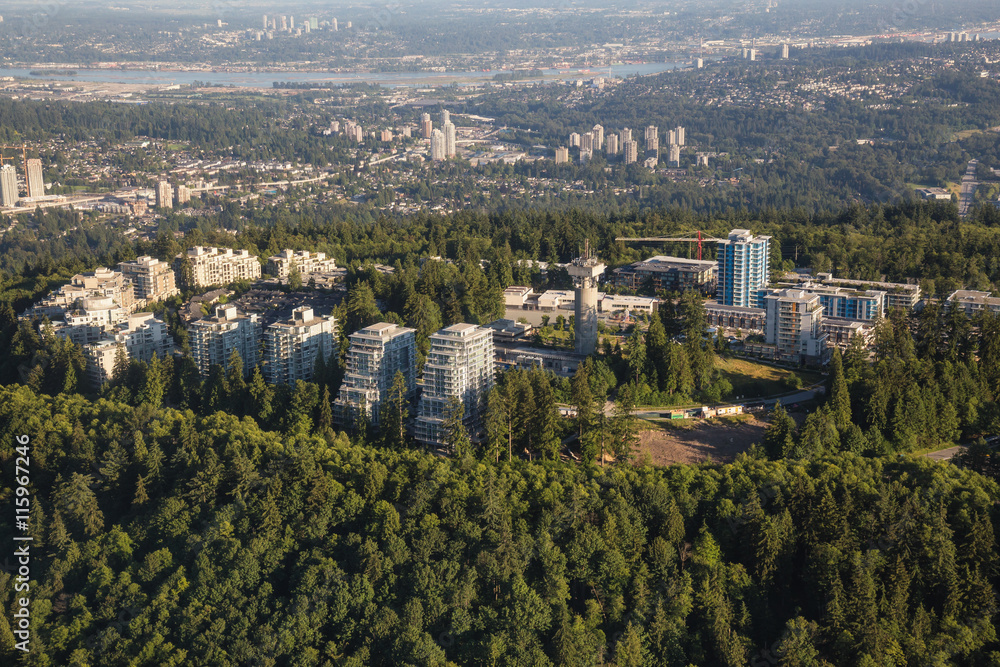 Obraz premium Aerial view of residential buildings on top of SFU (Burnaby Mountain). Picture taken from an airplane on a hazy sunny day in Vancouver, British Columbia, Canada.