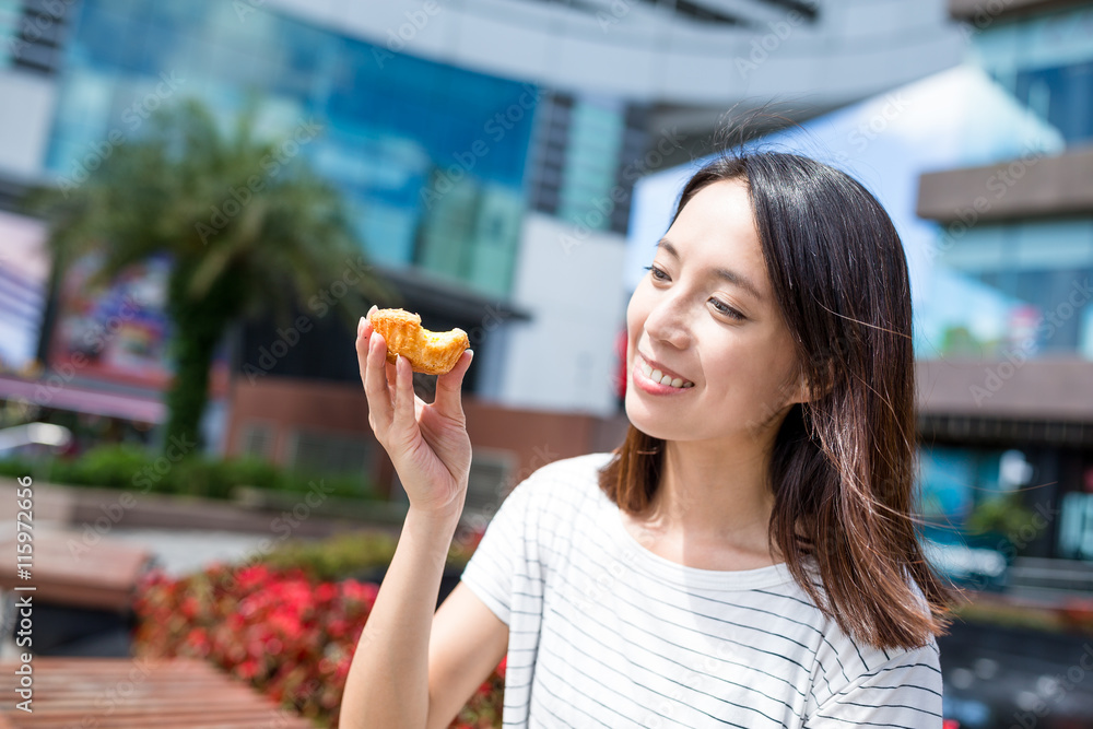 Woman having egg tart, Hong Kong local food Woman having egg tart, Hong Kong local food