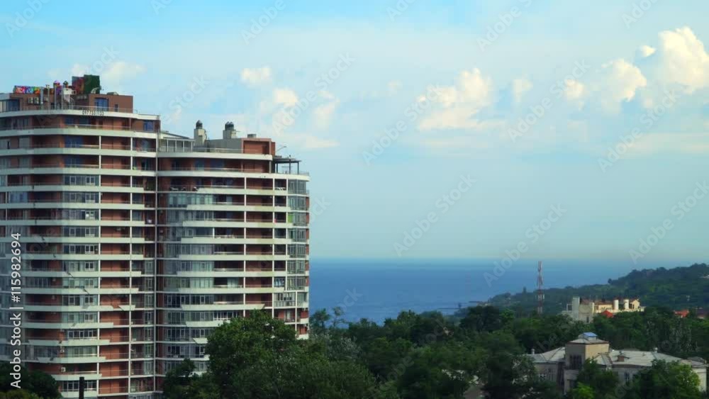 View of the city and the sea from the Ferris wheel. You can see the building, park, sea, sky with clouds View of the city and the sea from the Ferris wheel. You can see the building, park, sea, sky with clouds