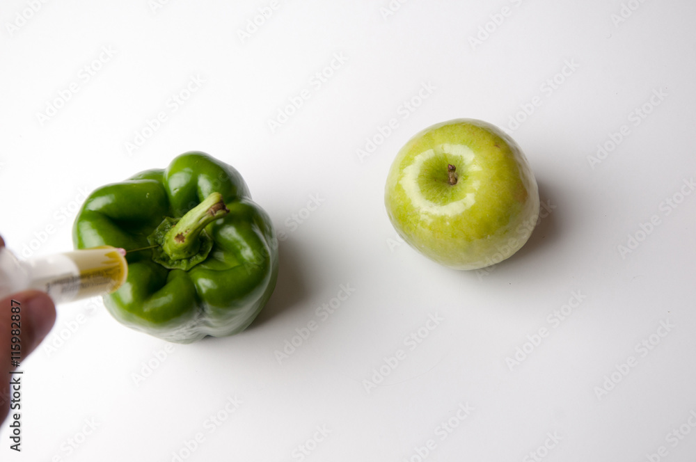 Pepper and apple infected gmo. White background. Pepper and apple infected gmo. White background.