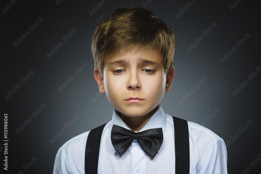 Portrait of offense crying boy isolated on gray background. Negative human emotion, facial expression. Closeup Portrait of offense crying boy isolated on gray background. Negative human emotion, facial expression. Closeup