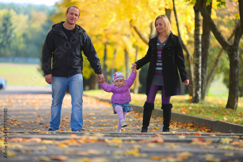 Young happy family on walk in autumn park