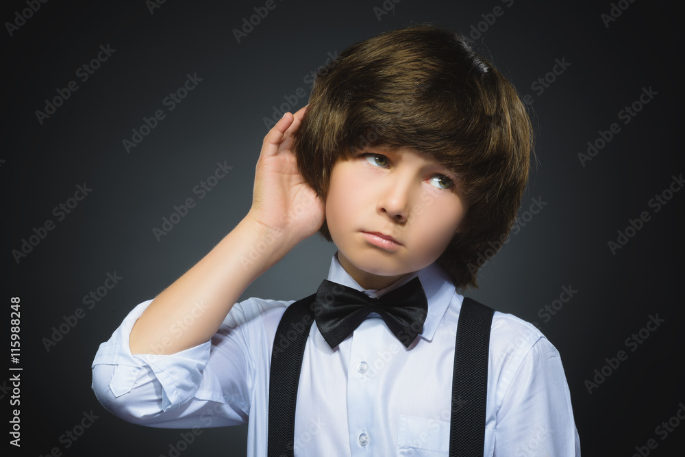 doubt, expression and people concept - boy thinking over gray background doubt, expression and people concept - boy thinking over gray background