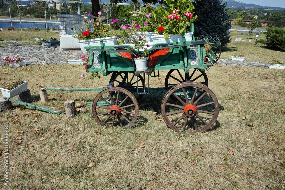 Wagon covered with flowers in the yard in Monastery St. John the Baptist, Kardzhali,  Bulgaria