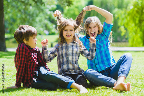 Smiling kids having fun at grass. Children playing outdoors in summer. teenagers communicate outdoor