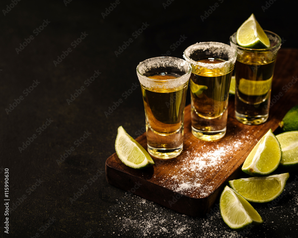 Mexican Gold Tequila with lime and salt on wooden table, selective focus. Copyspace. - obrazy, fototapety, plakaty 