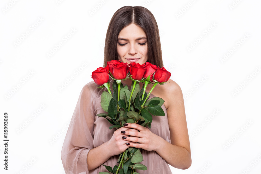 The most beautiful flowers for the most beautiful girl. Beautiful young woman in pretty dress holding bouquet of flowers while standing against white background The most beautiful flowers for the most beautiful girl. Beautiful young woman in pretty dress holding bouquet of flowers while standing against white background