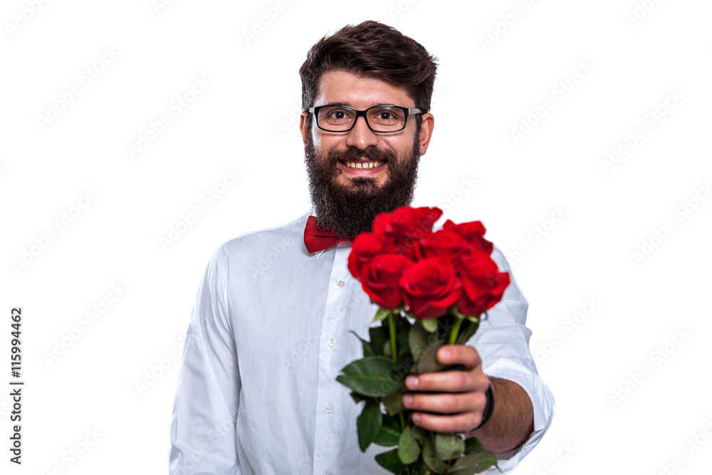 Charmingly chivalrous. Handsome young man giving a flower to you while standing against white background. Charmingly chivalrous. Handsome young man giving a flower to you while standing against white background.