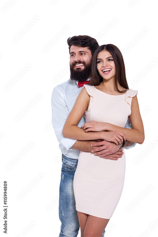 Enjoying every minute together. Handsome young man hugging his girlfriend and looking away while isolated on white. Enjoying every minute together. Handsome young man hugging his girlfriend and looking away while isolated on white.