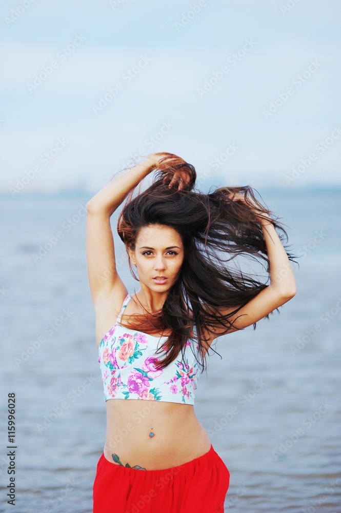 Naklejka premium Portrait of young beautiful woman wearing a t-shirt and red skir