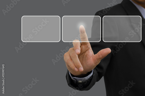 Businessman in black suit touching blank buttons on virtual screen.