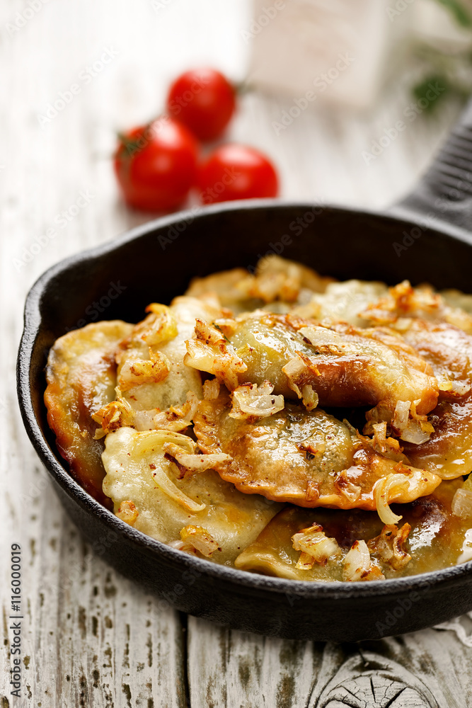 Baked dumplings on a cast-iron frying pan on wooden table Baked dumplings on a cast-iron frying pan on wooden table