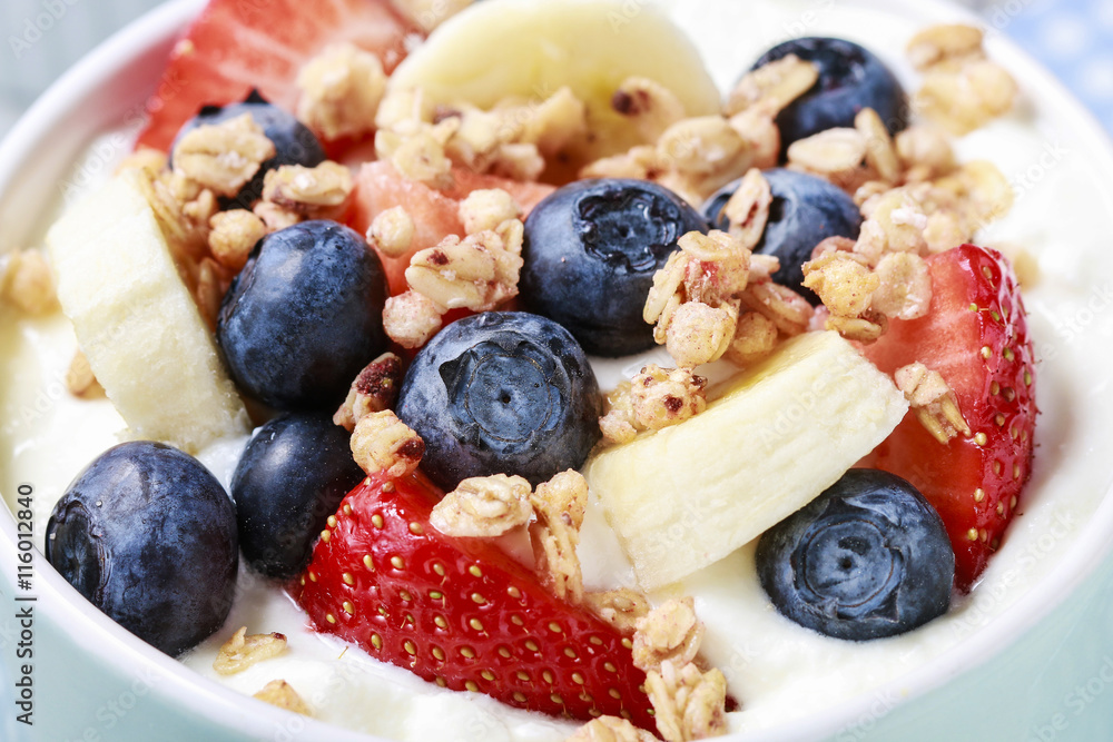 Bowl of yogurt with muesli and fresh fruits: strawberries, blueb Bowl of yogurt with muesli and fresh fruits: strawberries, blueb