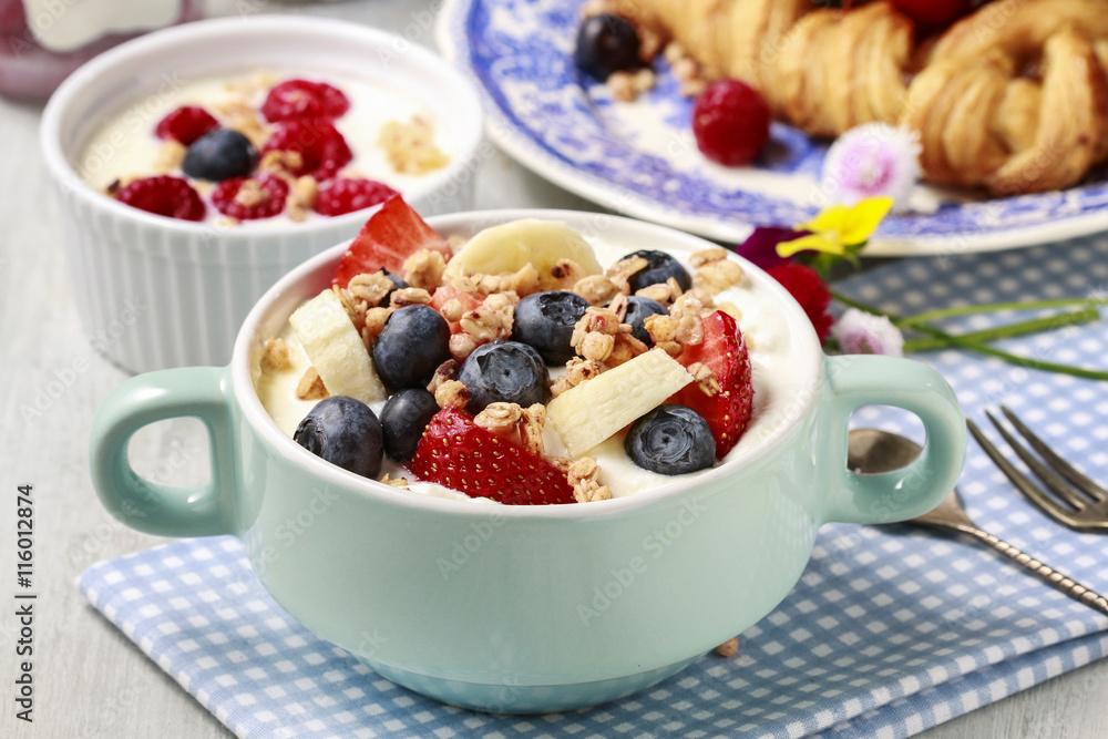 Bowl of yogurt with muesli and fresh fruits: strawberries, blueb Bowl of yogurt with muesli and fresh fruits: strawberries, blueb