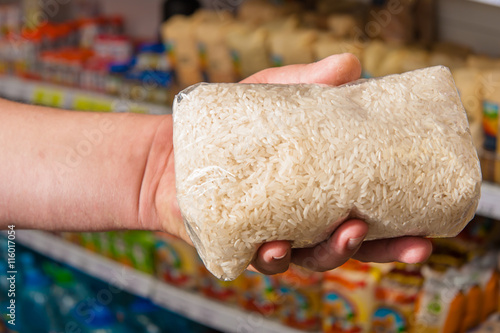 Package of rice in his hand