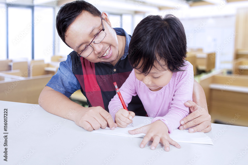 Elementary student studying with her teacher Elementary student studying with her teacher
