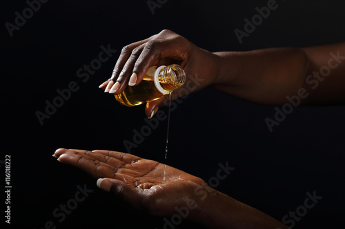 Fototapete mains femme noire s'enduisant d'huile de baobab