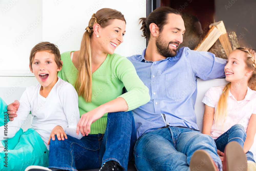 Family sitting at living room floor fireplace Family sitting at living room floor fireplace