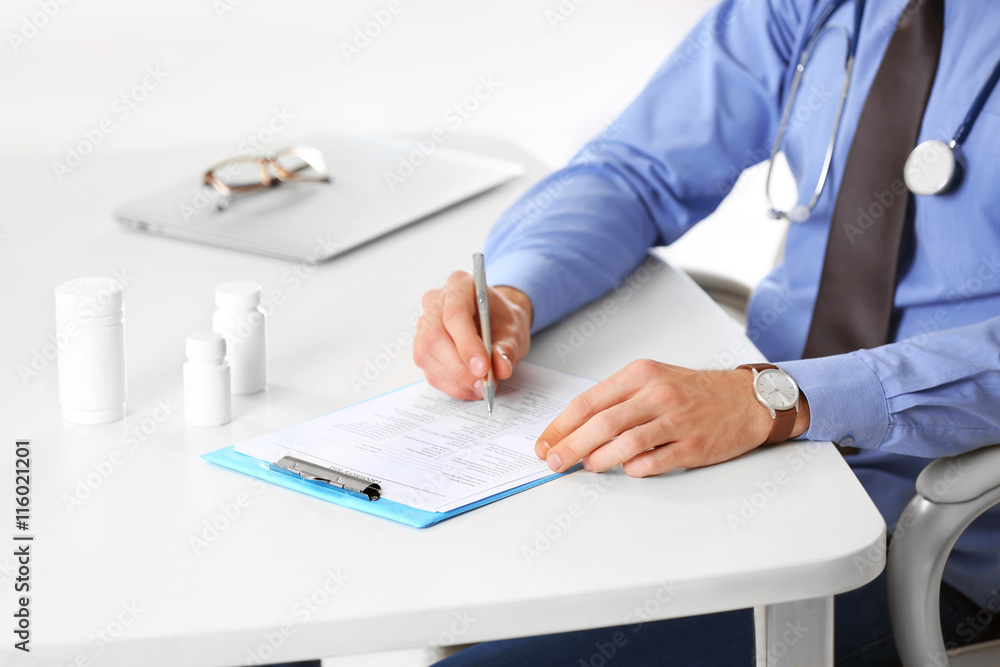 Doctor working at table in office Doctor working at table in office