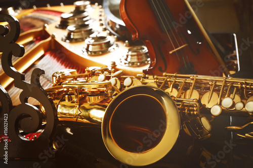 Violin and saxophone lying on piano, close up