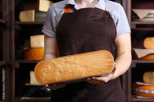 Woman holding a half wheel of fresh cheese