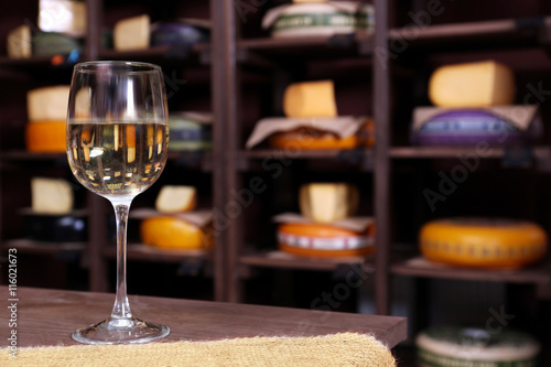 Glass of wine on the table in cellar with cheese