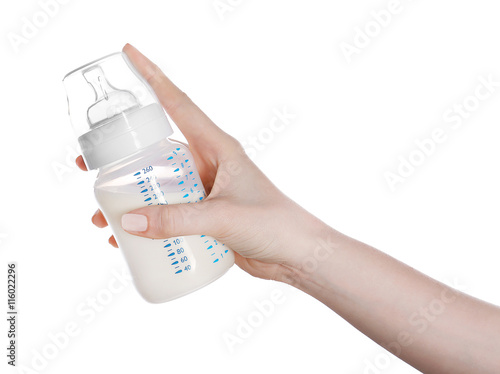 Female hand holding a baby bottle of milk on white background