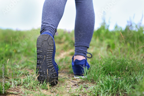 Female hiker walking on a trail at sunny day