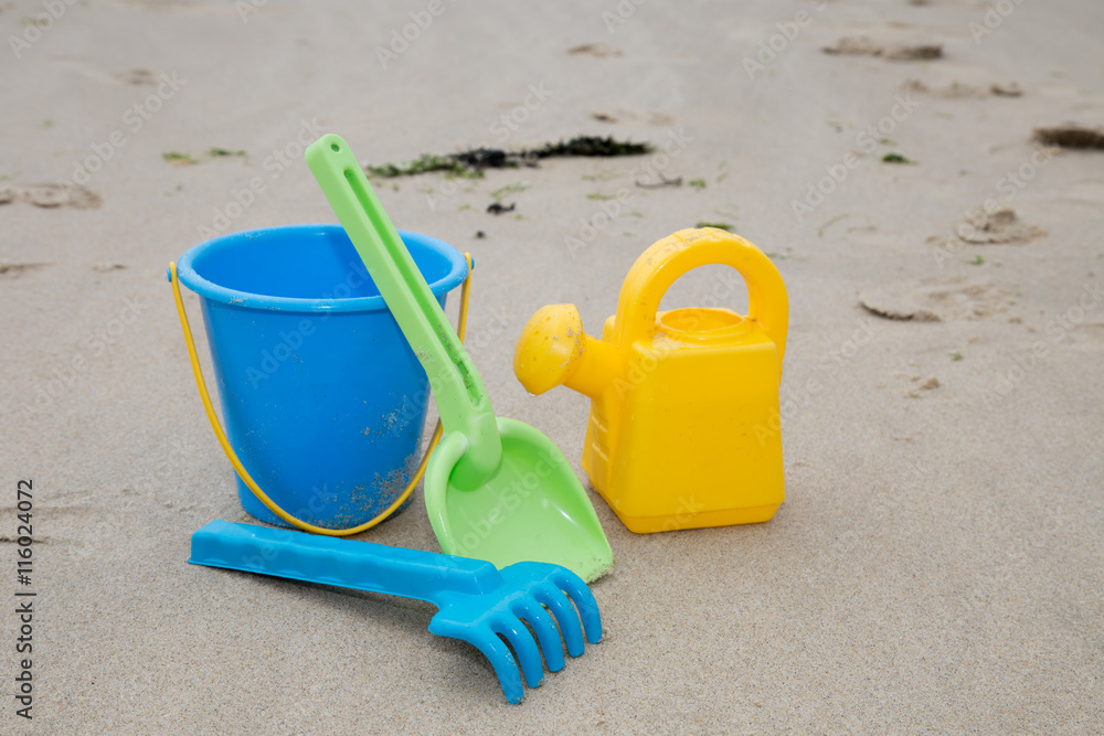 Beach toys in the sand at the beach Beach toys in the sand at the beach