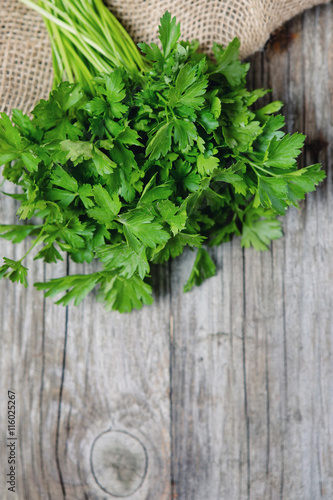 Fresh parsley on a wooden background and jute bags