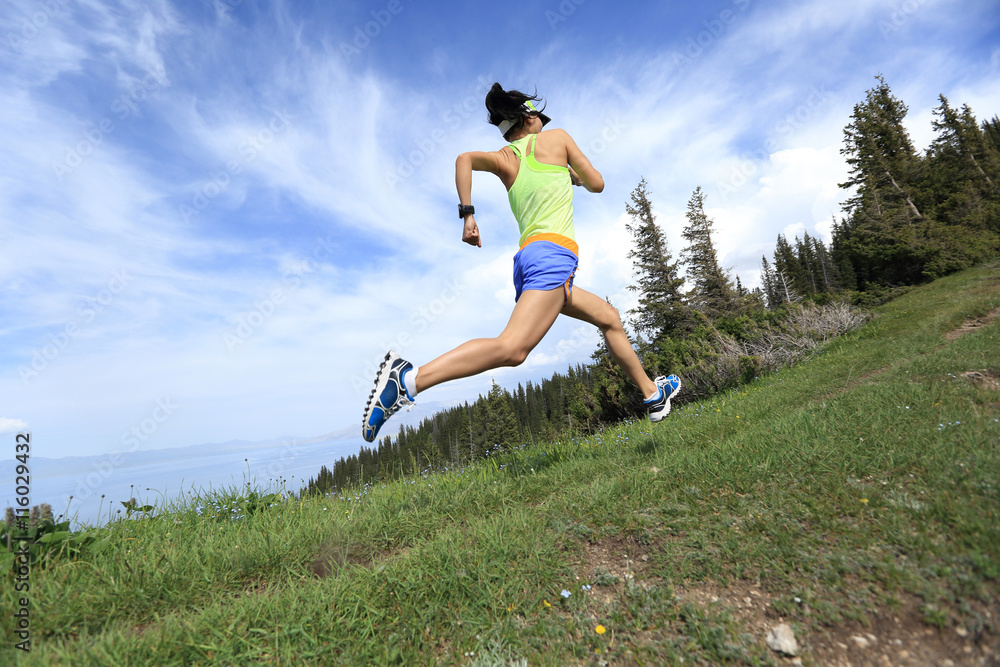 Obraz premium healthy young woman trail runner running on beautiful mountain peak
