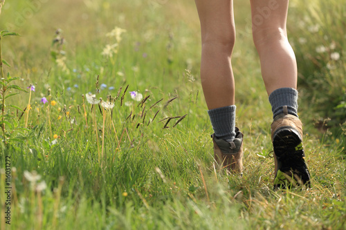young woman hiker legs walking on trail in grassland