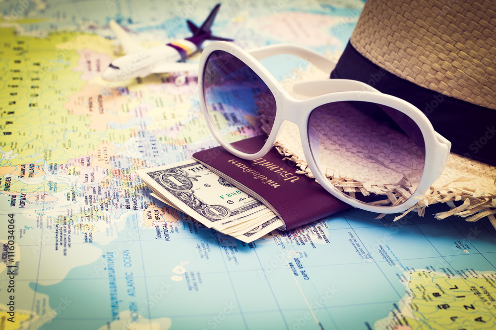 Obraz premium Sunglasses, Passport, Money, Hat and aircraft on the world map