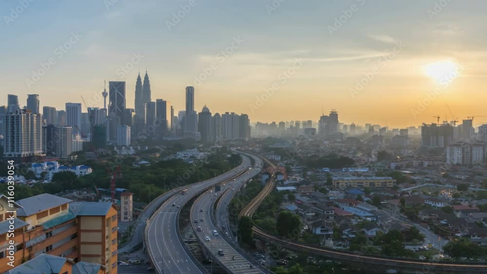 Majestic and beautiful day to night sunset time lapse at Kuala Lumpur city skyline. Showing sky changing colors and light trail from traffic on the road lead to the city. Pan right Majestic and beautiful day to night sunset time lapse at Kuala Lumpur city skyline. Showing sky changing colors and light trail from traffic on the road lead to the city. Pan right