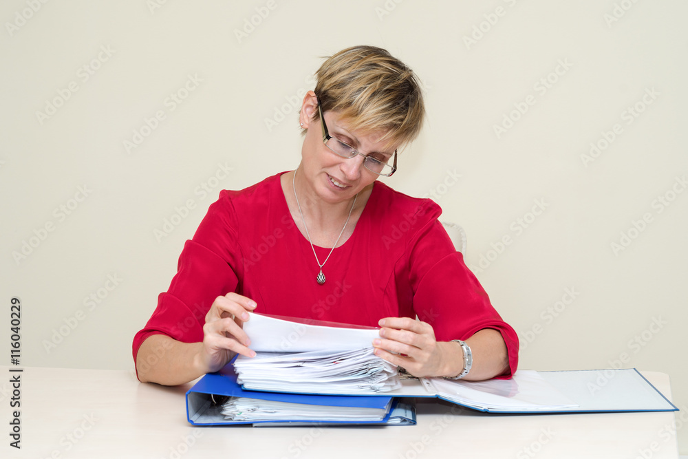 Business woman sitting at a table, carefully studying the documents folder Business woman sitting at a table, carefully studying the documents folder