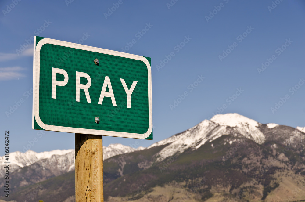Pray Sign with snow-covered Mountains in the background