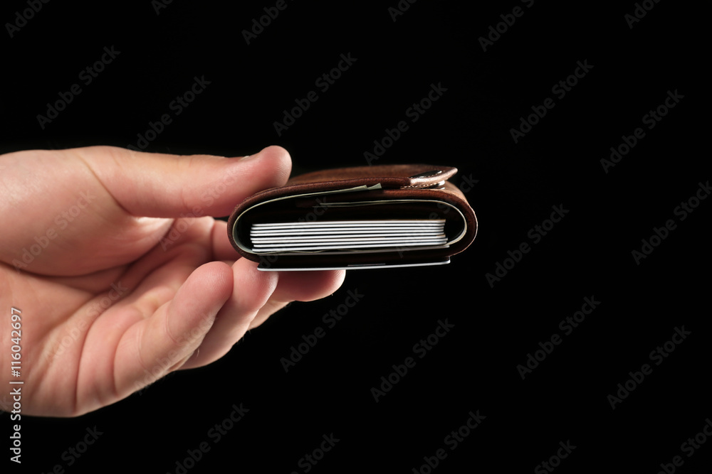 Fotografie Man holding wallet on black background
