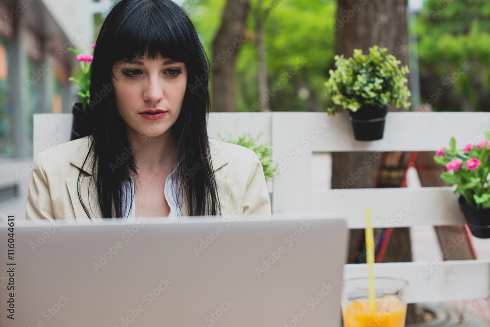 Portrait of woman working on laptop in outdoor cafe Portrait of woman working on laptop in outdoor cafe