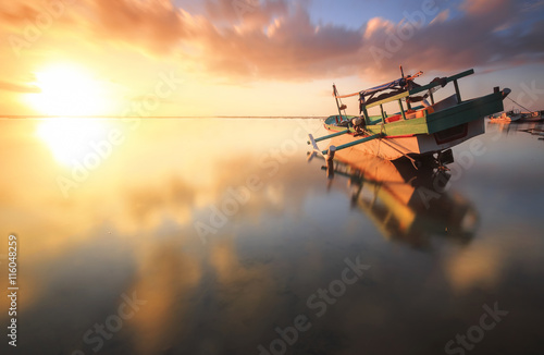 Traditional fisihing boats (outrigger canoes) moored off Bali's Tuban Beach, Indonesia. photo